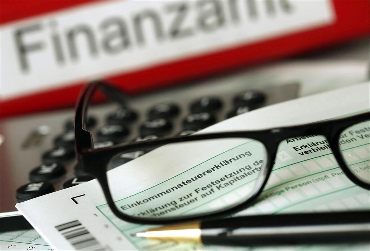 Eine Brille liegt vor einem Finanzamt Ordner. 