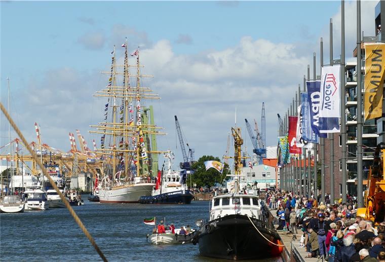 „Schulschiff Deutschland“: In Bremen sagt man Tschüss Kaje mit Menschen, Schiff fährt durch Schleuse.