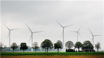 Windkraftanlagen hinter Feldern.
