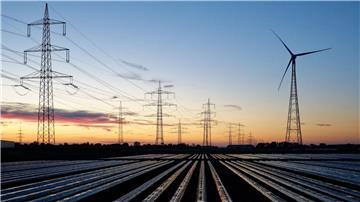 Windräder und Hochspannungsleitungen, aufgenommen am Morgen.