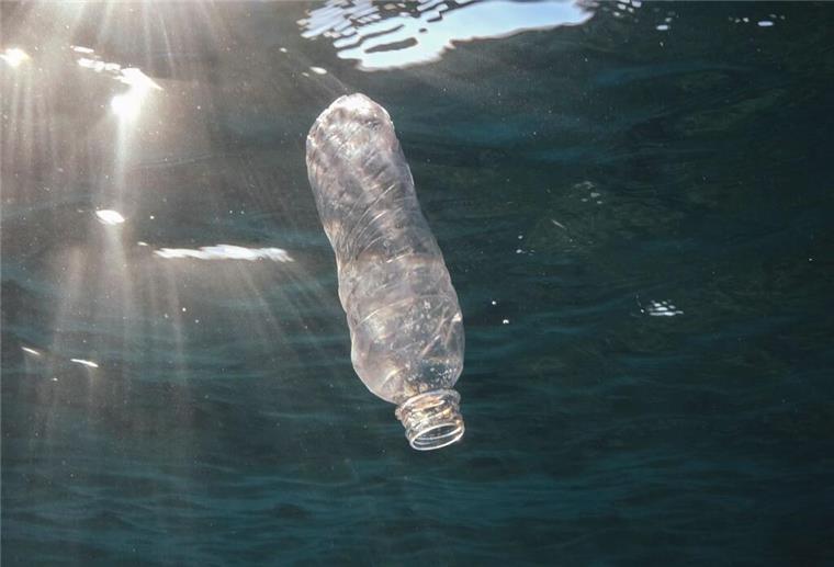 Eine weggeworfene Plastikflasche treibt im Roten Meer vor Ägypten und wird von der Sonne angestrahlt. (zu dpa: «Wie sich die Aufnahme von Mikroplastik vermindern lässt»)