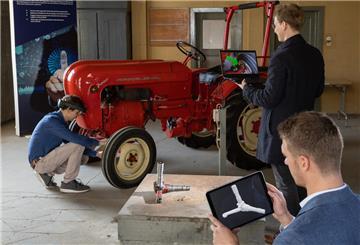 Wirtschaftsinformatiker Jonas Brinker (r) scannt zur Illustration einen Achsschenkel von einem Traktor Porsche Junior 108 mit einem Tablet und einer Software, die sich auf Künstliche Intelligenz stützt.