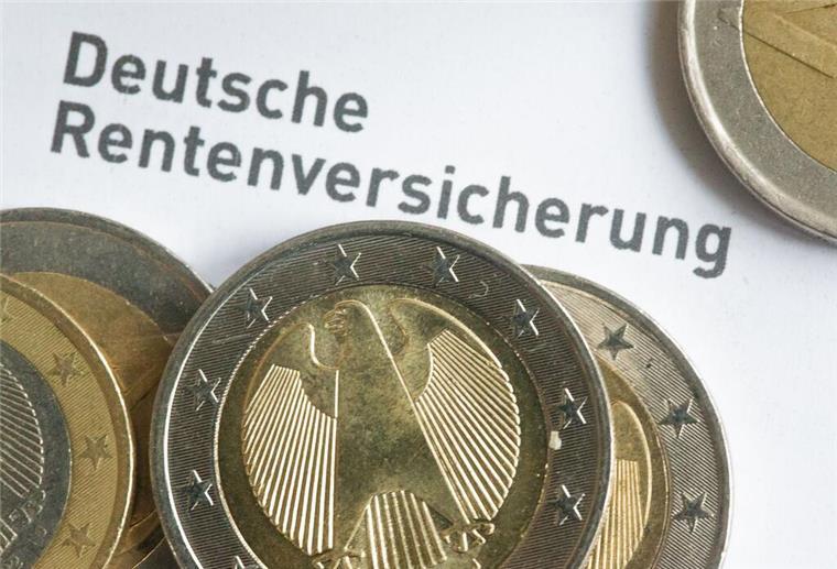 Einige Euro-Münzen liegen auf einem Rentenbescheid.