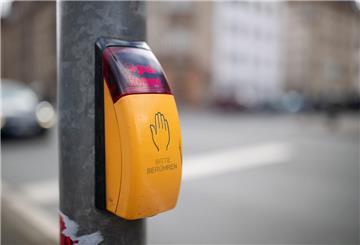 Durch das Drücken des Knopfes an der Unterseite des gelben Kastens soll die Ampel schneller auf grün springen.