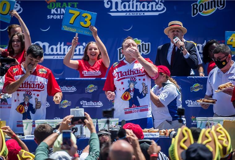 Wettessen in New York: Sieger verputzt 76 Hotdogs Wohl bekommt´s: Joey Chestnut (Mitte) beim Wettessen auf Coney Island. Am Ende verdrückte er 76 Hotdogs - Weltrekord.