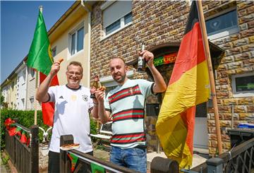 Wolfgang Juschkat (links) und Sérgio Padinha freuen sich mit Pastéis de Nata, Bockwust und Bier beider Nationen auf das Länderspiel Portugal-Deutschland bei der Fußball-Europameisterschaft.