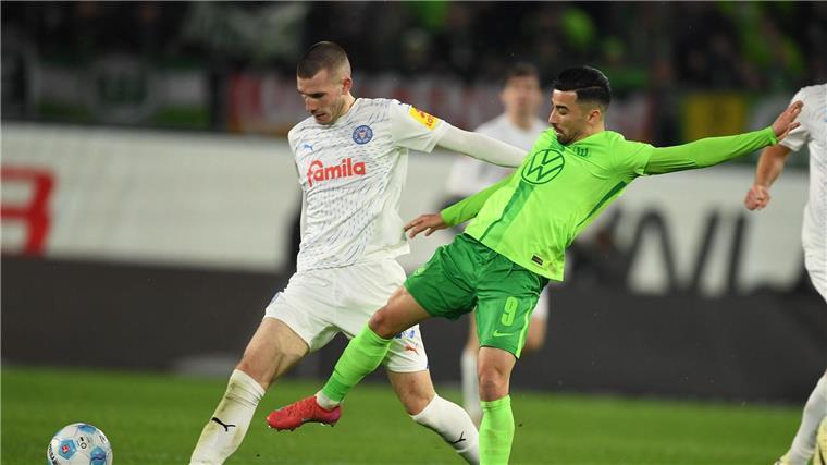 Wolfsburgs Mohamed Amoura (r) spielt gegen Kiels David Zec.