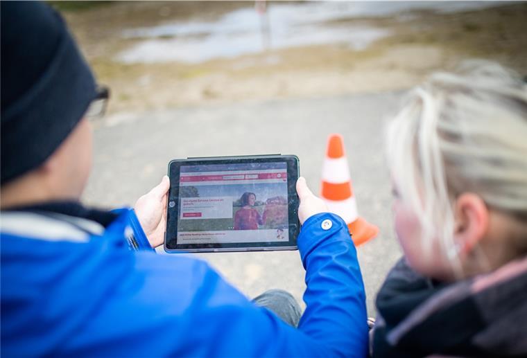 Yvonne und Marvin Holst blicken auf das Tablet mit der Seite der Weser-Elbe Sparkasse Foto: Hartmann