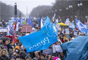 Zahlreiche Menschen mit Fahnen und Transparenten nehmen an der Demonstration teil.