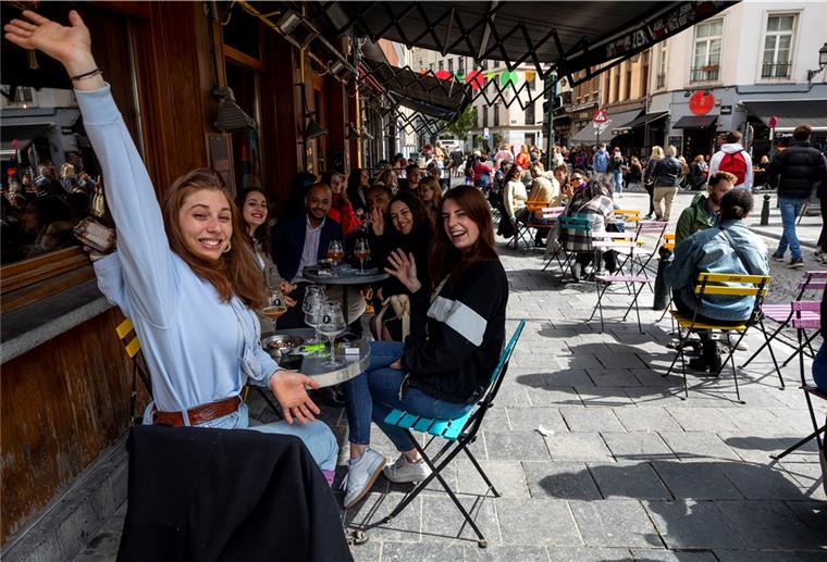 Zahlreiche Menschen sitzen an den Tischen im Außenbereich der Bars und Restaurants und feiern.