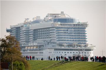 Zahlreiche Schaulustige stehen in der Nähe des Ems-Sperrwerkes Gandersum auf einem Deich und beobachten die Überführung des Kreuzfahrtschiffes "AIDAnova" auf der Ems. 

