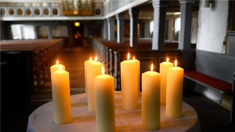 Gottesdienst: Trauernde gedenken Opfern von Radlader-Unfall Zehn Kerzen für Beteiligte und Opfer stehen auf einem Tisch vor dem Altar in der St. Johannis Kirche.