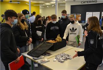 Sieben IGS-Schüler stehen am Stand von Zollamtfrau Sybille Gradistanac.