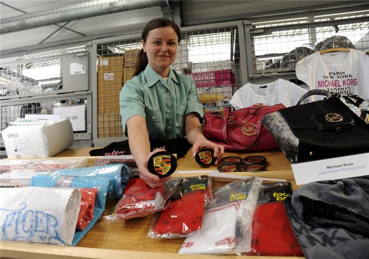 Zollsekretärin Ramona Behrens präsentiert einige der gefälschten Waren, die der Zoll in Bremerhaven sichergestellt hat.
