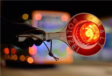 Ein Polizist hält eine Warnkelle in der Hand.