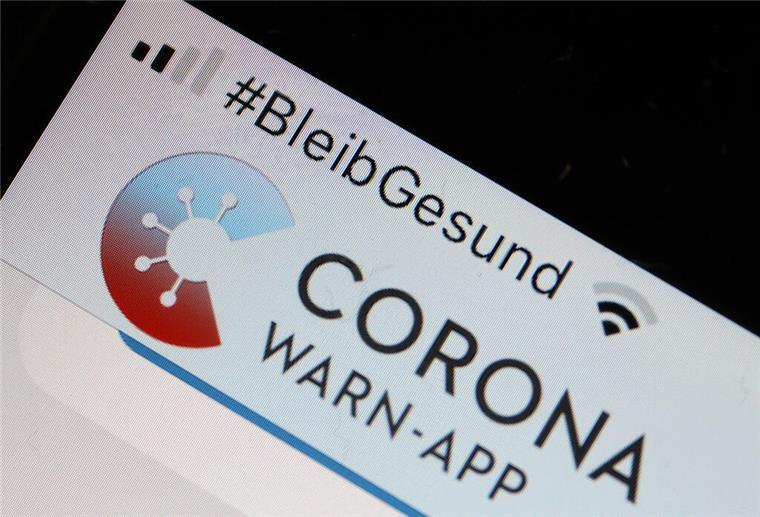 Die Corona-Warn-App mit der Seite zur Risiko-Ermittlung ist im Display eines Smartphone zu sehen