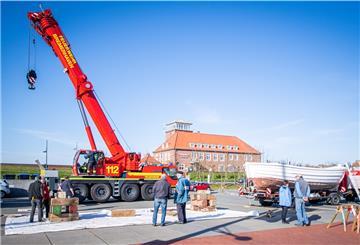 Zurück aus der Werft: Das Börteboot No. 3 wird mit einem Feuerwehr-Oldtimer zum Neuen Hafen gebracht und per Kran an Land aufgebockt. 