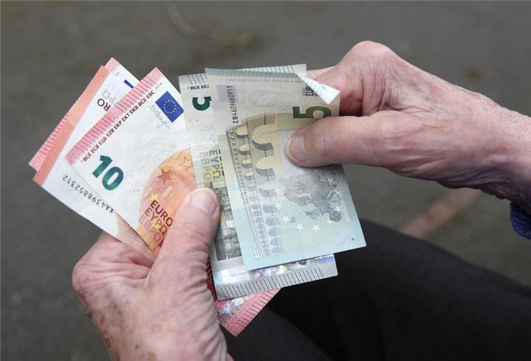 Knallharte Regel kommt: Tausende Bürger können bald in die Rente gezwungen werden Eine Seniorin haelt Geldscheine in ihrer Hand. Ab 2027 können Bürger unter bestimmten Voraussetzungen zur Rente gezwungen werden.