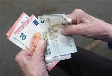 Eine Seniorin haelt Geldscheine in ihrer Hand. Ab 2027 können Bürger unter bestimmten Voraussetzungen zur Rente gezwungen werden.