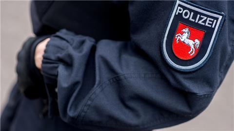 Eine Polizeibeamtin steht im Innenhof einer Polizeiinspektion 