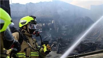 Zwei Feuerwehrmänner löschen das Feuer in der Halle.