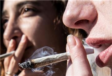 Zwei Frauen rauchen bei einer Protestaktion für legalen Cannabis-Konsum  einen Joint. 