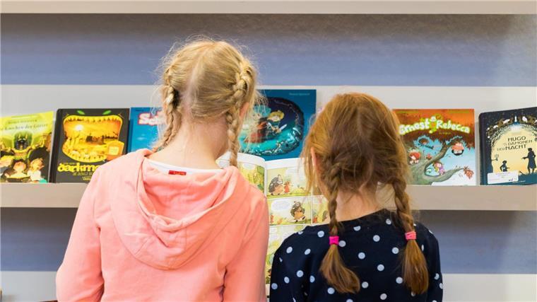 Oldenburger Kinder- und Jugendbuchmesse startet Zwei Mädchen stehen bei der „Kibum“ (Kinder- und Jugendbuchmesse) in der Stadtbibliothek PFL.