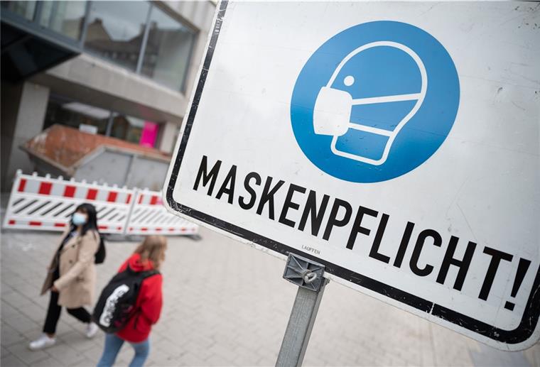 Maskenpflicht in Cuxhaven: Stoffmaske reicht Zwei Passantinnen gehen in einer Fußgängerzone hinter einem Schild vorbei, auf dem „Maskenpflicht“ steht.