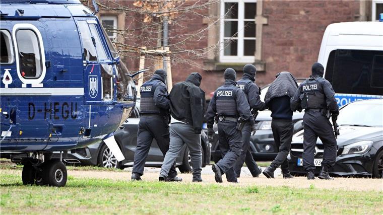 Mutmaßliche Hisbollah-Mitglieder sollen vor Gericht kommen Zwei Personen werden von Polizisten von einem Hubschrauber zu einem Auto geführt.