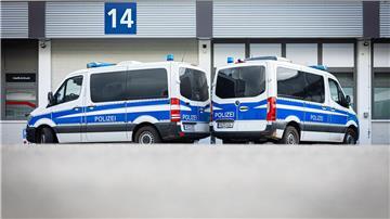 Zwei Polizeiautos stehten während einer Durchsuchung auf einem Hof.