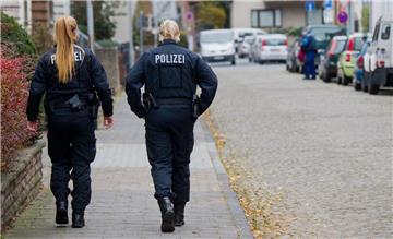 Zwei Polizistinnen gehen am Montag über eine Straße in Hameln. Hier hatte am Vorabend ein Mann eine junge Frau mit einem Seil an die Anhängerkupplung eines Autos gebunden und rund 250 Meter weit durch die Stadt geschleift.