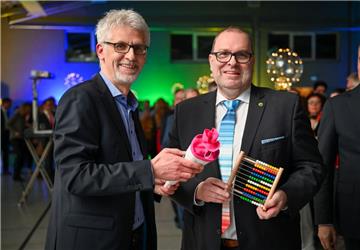 Zwei Präsente mit Symbolkraft: NZ-Redaktionsleiter Christian Döscher (links) überreicht Geestlands Bürgermeister Thorsten Krüger eine Schultüte und einen Rechenschieber.